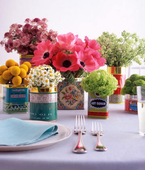 un arreglo de flores y latas para decorar mesas